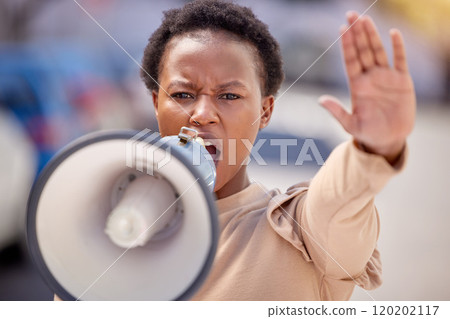 Fight for what you believe in. Shot of a young woman with her hand raised speaking through a megaphone at a protest. Fight for what you believe in. Shot of a young woman with her hand raised speaking through a megaphone at a protest. 120202117