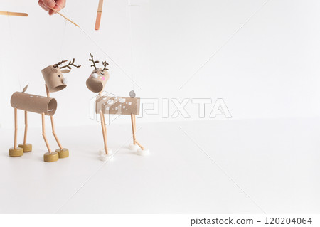 Step-by-step tutorial for DIY reindeer puppet craft using cardboard tubes, bottle caps, Easy Christmas holiday project idea for kids and adults. Recycling and upcycling holiday decoration concept, 120204064