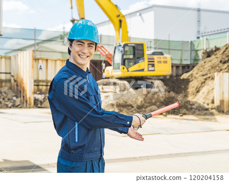 A worker directing traffic in front of a construction site 120204158