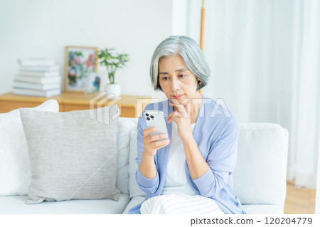 在客廳裡操作智能手機的女高管 120204779