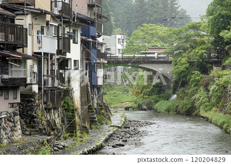 A castle town in the mountains, with old houses lined up along the river 120204829