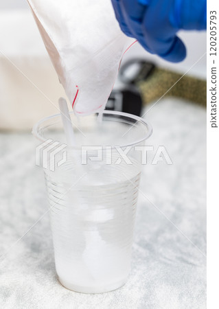 Pouring Glucose Powder into Water for Glucose Tolerance Test 120205793