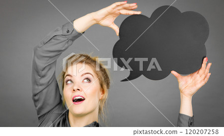 Shocked woman holding black thinking bubble Shocked woman holding black thinking bubble 120207258