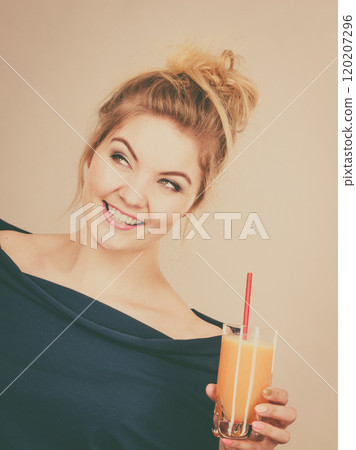 Happy woman holding fresh orange juice Happy woman holding fresh orange juice 120207296