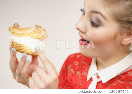 Funny woman holds cream puff cake Funny woman holds cream puff cake 120207441