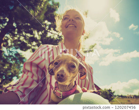 Woman playing pinscher ratter dog outside Woman playing pinscher ratter dog outside 120207456