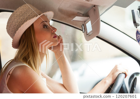 Distracted woman driving her car looking in mirror Distracted woman driving her car looking in mirror 120207601