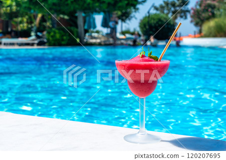 Frozen red drink by the pool on sunny day. Concept of refreshing summer poolside relaxation 120207695