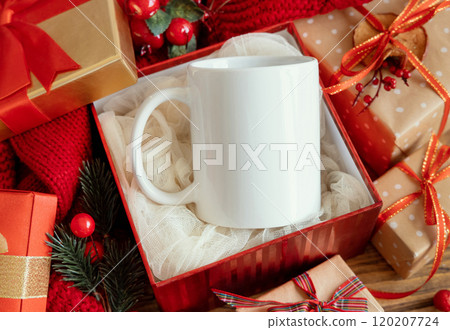 White coffee mug in gift box near red Christmas decor and lights, winter mockup White coffee mug in gift box near red Christmas decor and lights, winter mockup 120207724