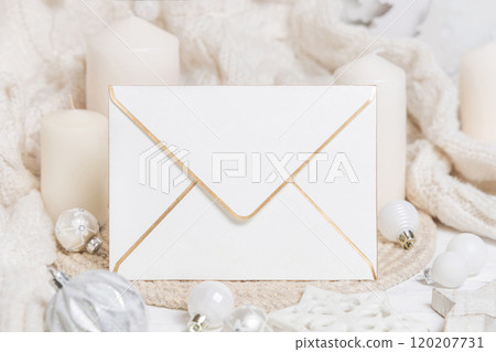 Blank envelope near white knitted sweater, pillar candles and Christmas decor, mockup 120207731
