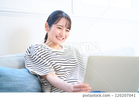 看電腦螢幕、客廳、工作室的年輕女性 120207841