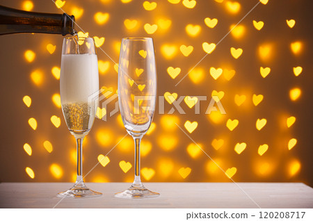 beautiful glasses of champagne on a blurred background of hearts 120208717