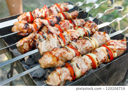 Cooking barbecue with vegetables on skewers. Roasted meat on the grill Cooking barbecue with vegetables on skewers. Roasted meat on the grill 120208719