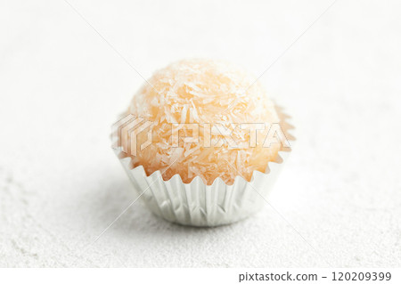 Typical Brazilian sweet brigadeiro. One coconut candy on a white background 120209399