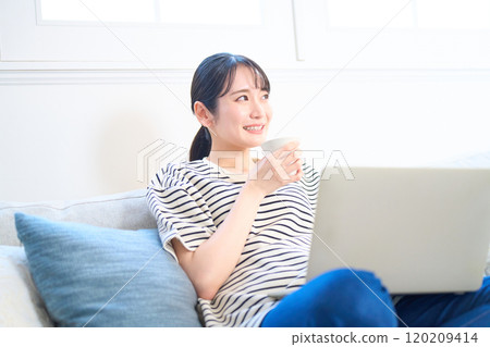 看電腦螢幕、客廳、工作室的年輕女性 120209414