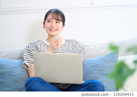 看電腦螢幕、客廳、工作室的年輕女性 120209415