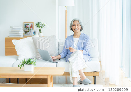 在客廳裡操作電腦的老婦人 120209909