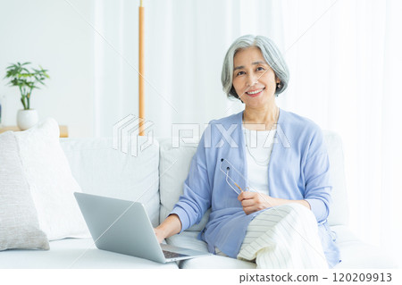 在客廳裡操作電腦的老婦人 120209913