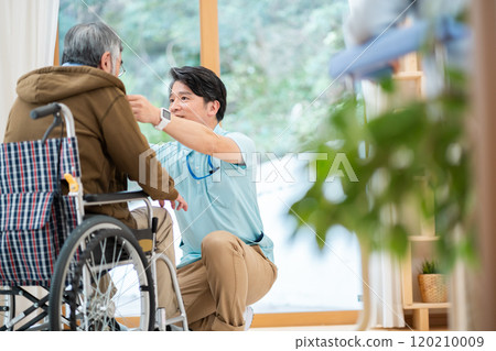 A male caregiver talking to a nursing home resident A male caregiver talking to a nursing home resident 120210009