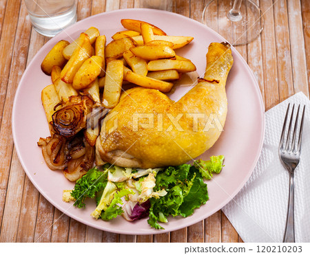 Chicken leg with baked potatoes, browned onions and fresh salad Chicken leg with baked potatoes, browned onions and fresh salad 120210203