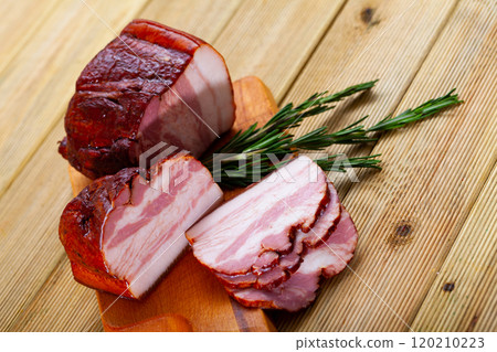 Sliced smoked bacon on wooden table Sliced smoked bacon on wooden table 120210223