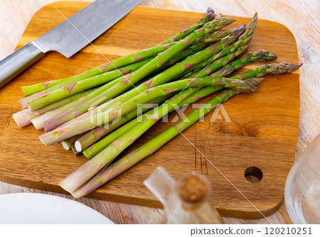 Fresh green asparagus on wooden board ready for cooking 120210251