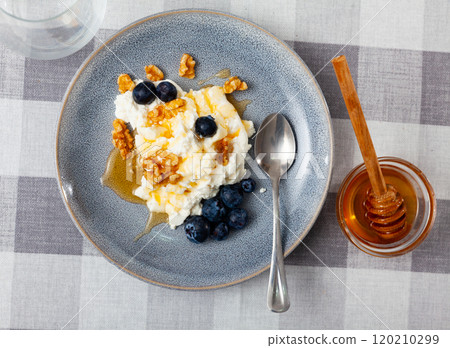 Farm cottage cheese filled with large amount of honey with walnut and blueberry. Farm cottage cheese filled with large amount of honey with walnut and blueberry. 120210299