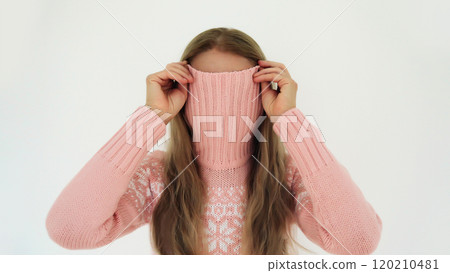 Funny young woman covering her face with knitted sweater or having fun standing on white background Funny young woman covering her face with knitted sweater or having fun standing on white background 120210481