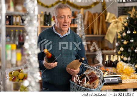 Happy mature man buying bottles of wine at grocery supermarket to celebrate Christmas 120211027