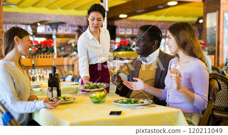 Couple eating in restaurant with their female friend during date 120211049