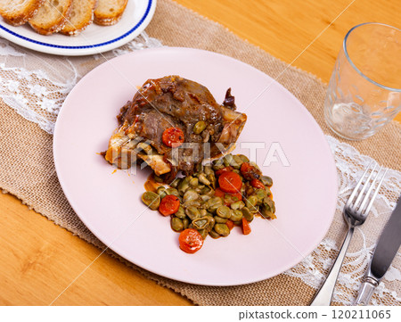 Pork cheeks served with beans on plate 120211065