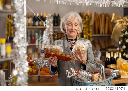 Elderly woman choosing marzipan and panellets in grocery store 120211074