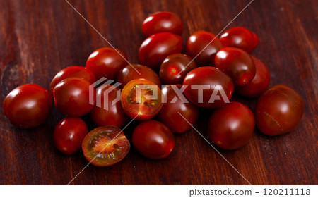 Ripe red cultivated species kumato tomatoes on wooden background. Healthy vitamin product Ripe red cultivated species kumato tomatoes on wooden background. Healthy vitamin product 120211118