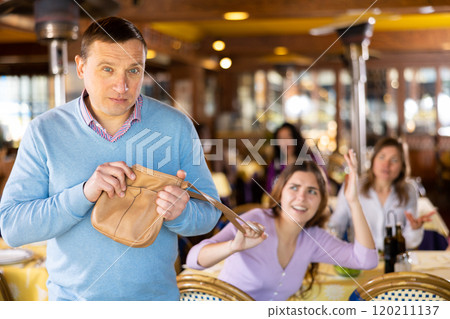 Man leaving restaurant after stealing woman's handbag 120211137