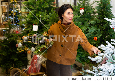 Asian woman buying christmas tree 120211181