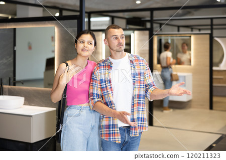 Man and woman looking around in bathroom department of store Man and woman looking around in bathroom department of store 120211323