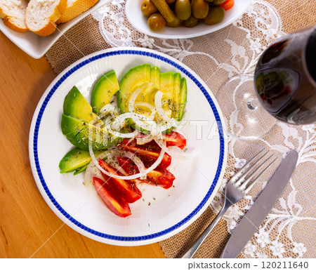 Salad from ripe avocado with tomatoes and onions Salad from ripe avocado with tomatoes and onions 120211640