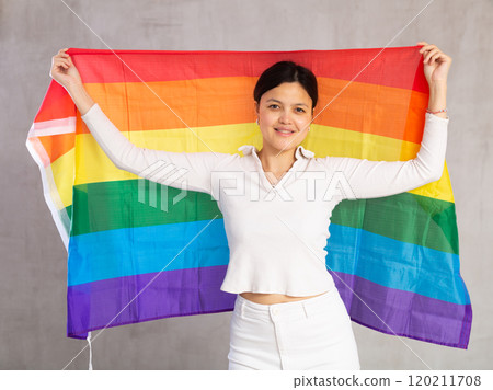 Portrait of playful girl holding an LGBT flag in her hands Portrait of playful girl holding an LGBT flag in her hands 120211708