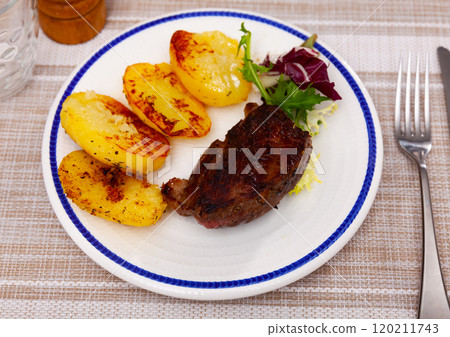 Appetizing grilled beef meat with potato and salad with arugula 120211743