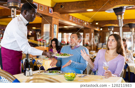 Man and woman quarreling with waiter in restaurant Man and woman quarreling with waiter in restaurant 120211983