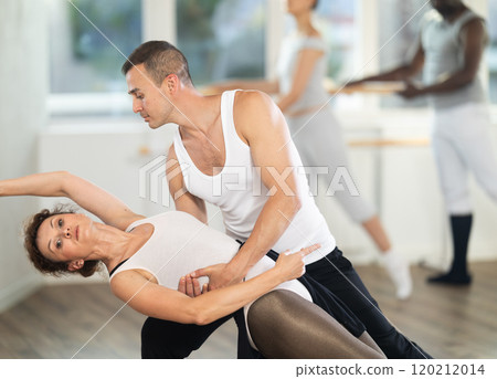 Man and girl woman together arabesque position of ballet during choreography studio Man and girl woman together arabesque position of ballet during choreography studio 120212014