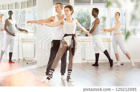 Couple of ballet dancers showcasing supports during group class Couple of ballet dancers showcasing supports during group class 120212095