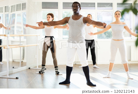 African American man leading ballet class with amateur dancers African American man leading ballet class with amateur dancers 120212143