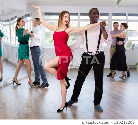 Woman with African man dancing waltz in couple during lesson at studio Woman with African man dancing waltz in couple during lesson at studio 120212202