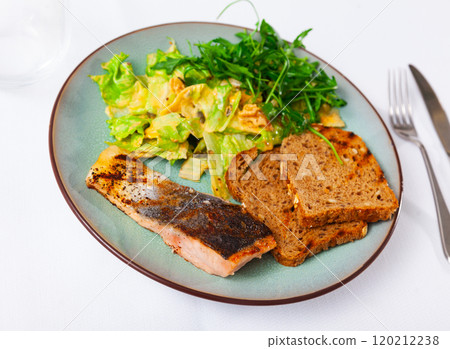 Baked salmon steak with toasts and Mediterranean salad Baked salmon steak with toasts and Mediterranean salad 120212238