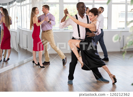 Middle-aged man and woman practicing waltz in dancing studio Middle-aged man and woman practicing waltz in dancing studio 120212362