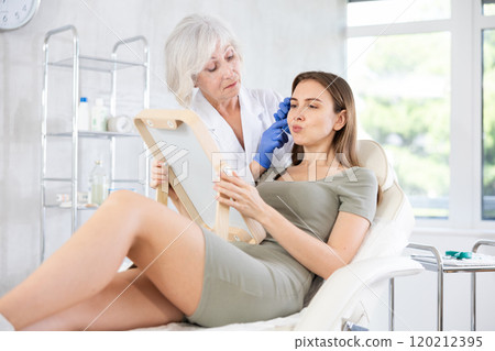 Young patient looking in mirror at clinic. 120212395