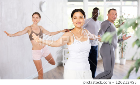 Smiling Asian woman learning to dance waltz together with adult man Smiling Asian woman learning to dance waltz together with adult man 120212453