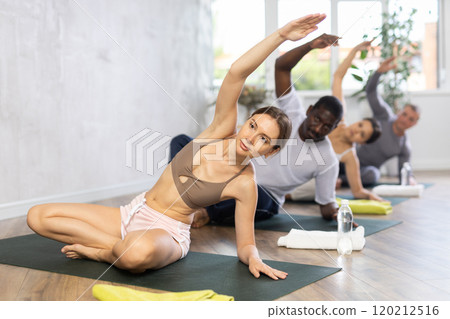 Women and men practicing yoga lesson at sport club 120212516
