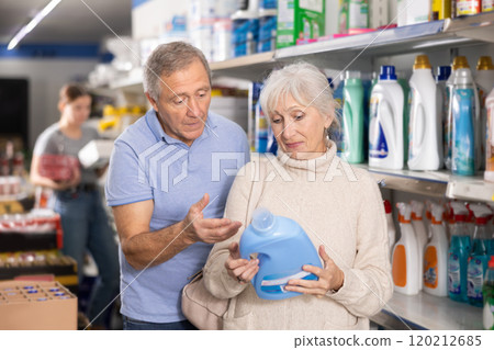 Positive elderly couple buying household chemicals in supermarket 120212685